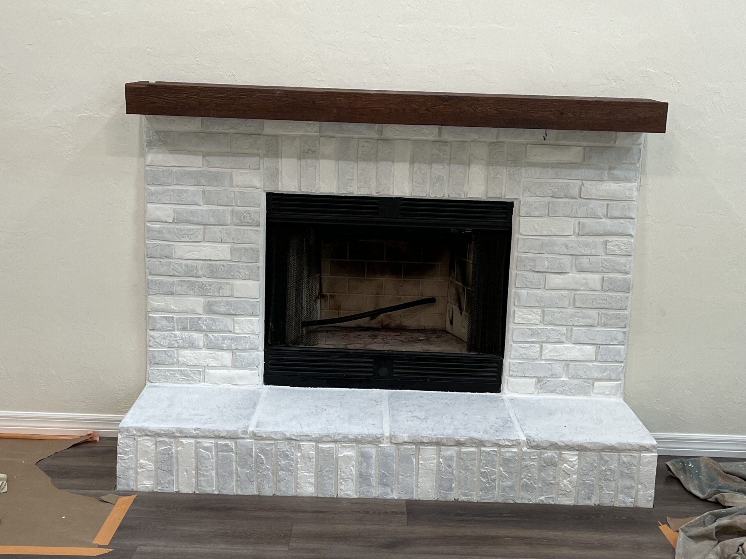Whitewashed brick fireplace with custom stained mantel