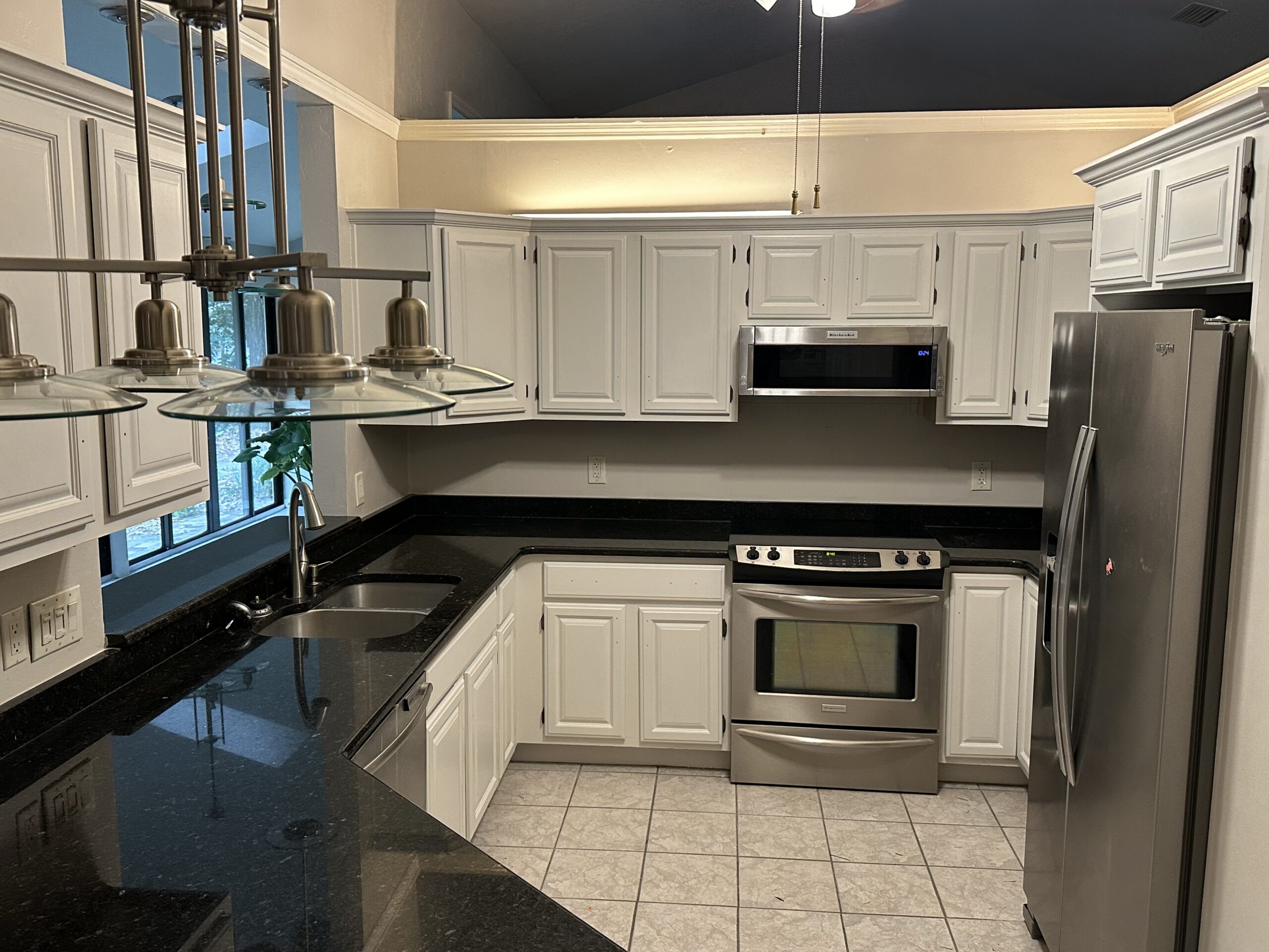 White cabinets over black granite by Color Pros Painting